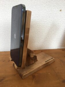 木製角度調整スマホスタンドにiphoneが載っている。角度は急