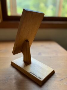 窓際の机の上の木製スマホスタンド　斜め左後ろ