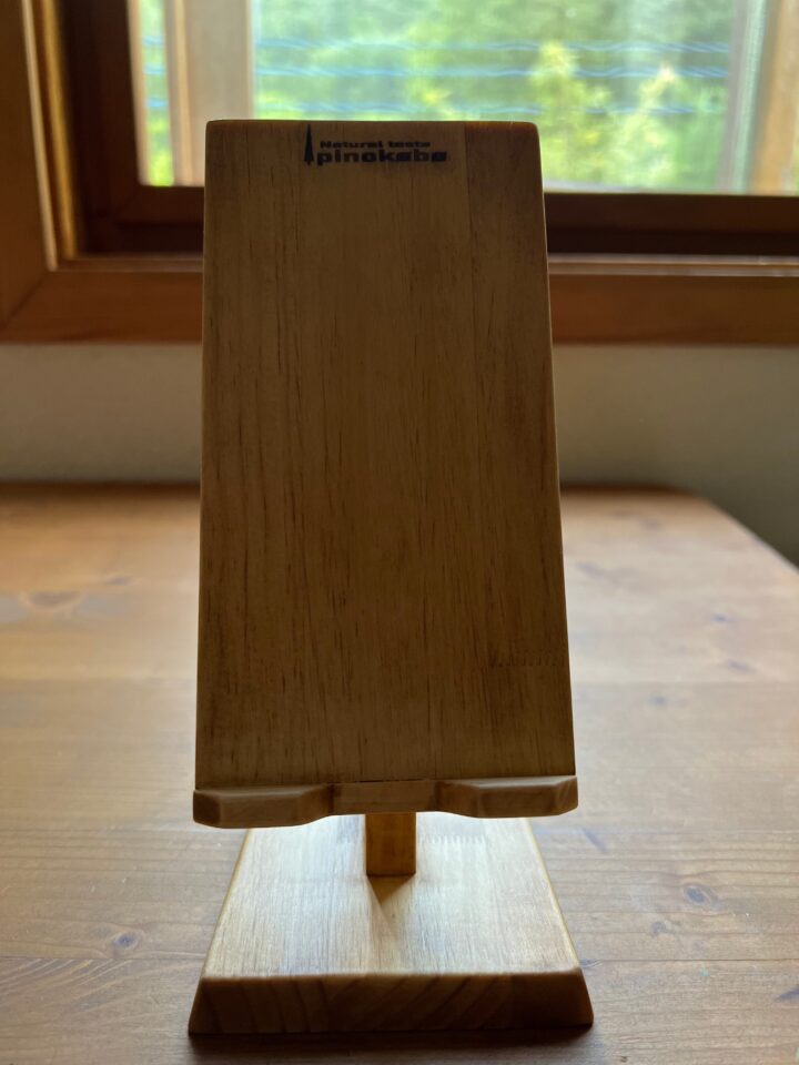 窓際の机の上の木製スマホスタンド　正面