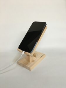 木製スマホスタンドでスマホ充電中