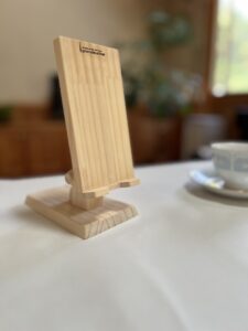 リヴィングのテーブルの上に置いてある木製シマホスタンドとコーヒ＾カップ