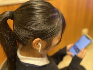 iphoneで音楽を楽しんでいる女子