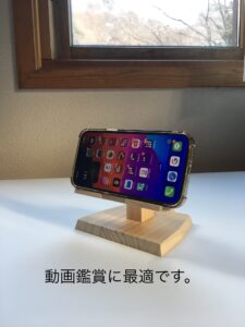 木製スマホスタンドに乗るスマートフォン