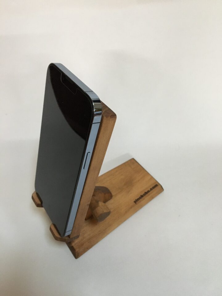 木製スマホスタンドiphoneが載っている、