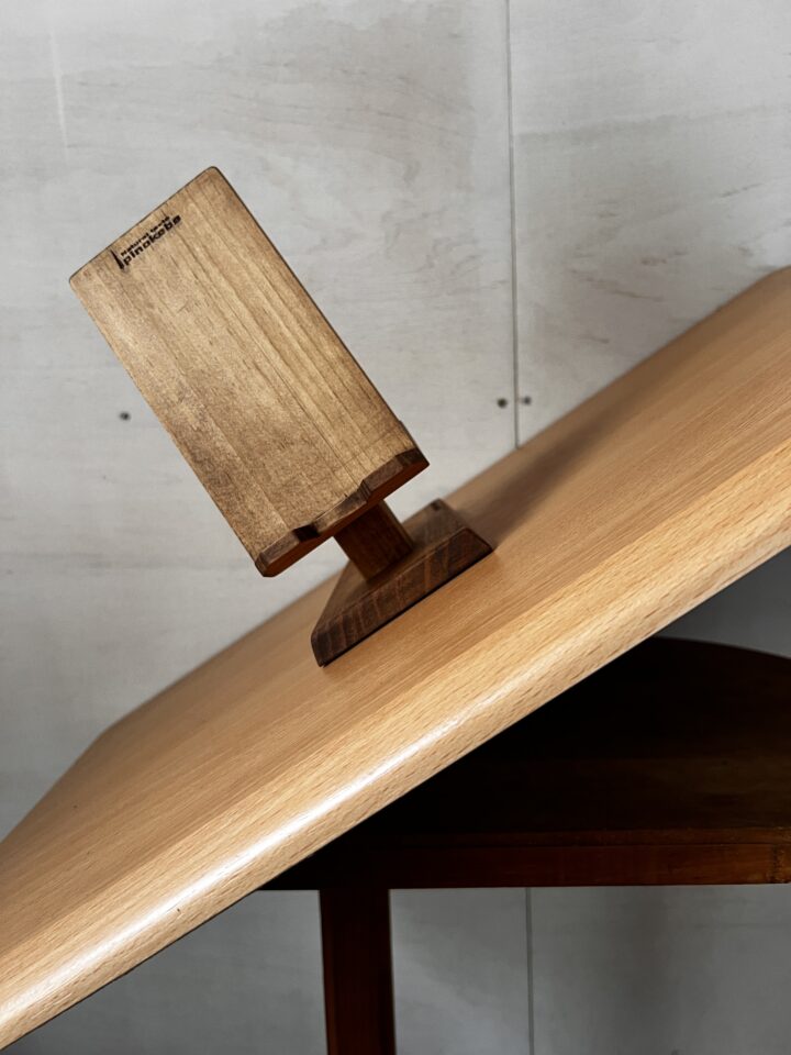 木製スマホスタンドを傾けている